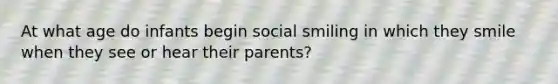 At what age do infants begin social smiling in which they smile when they see or hear their parents?