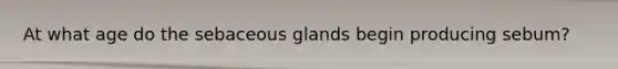 At what age do the sebaceous glands begin producing sebum?