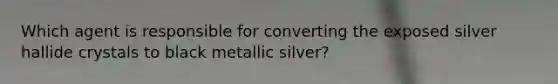 Which agent is responsible for converting the exposed silver hallide crystals to black metallic silver?