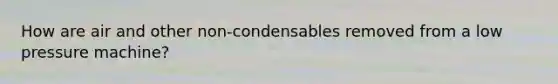 How are air and other non-condensables removed from a low pressure machine?