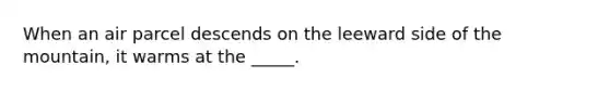 When an air parcel descends on the leeward side of the mountain, it warms at the _____.