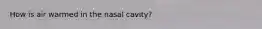 How is air warmed in the nasal cavity?