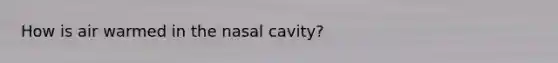 How is air warmed in the nasal cavity?