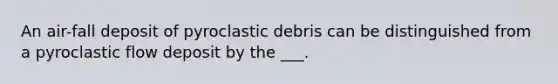 An air-fall deposit of pyroclastic debris can be distinguished from a pyroclastic flow deposit by the ___.