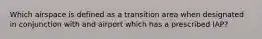 Which airspace is defined as a transition area when designated in conjunction with and airport which has a prescribed IAP?