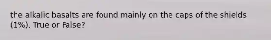 the alkalic basalts are found mainly on the caps of the shields (1%). True or False?