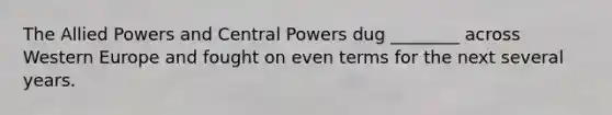 The Allied Powers and Central Powers dug ________ across Western Europe and fought on even terms for the next several years.