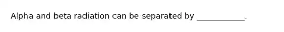 Alpha and beta radiation can be separated by ____________.