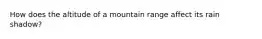 How does the altitude of a mountain range affect its rain shadow?