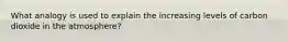 What analogy is used to explain the increasing levels of carbon dioxide in the atmosphere?