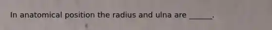 In anatomical position the radius and ulna are ______.