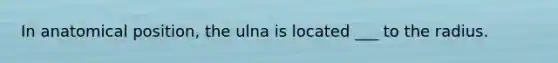 In anatomical position, the ulna is located ___ to the radius.