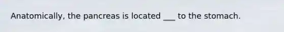 Anatomically, the pancreas is located ___ to the stomach.