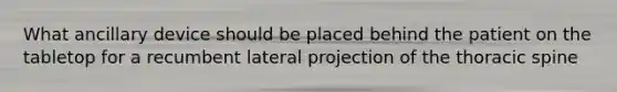 What ancillary device should be placed behind the patient on the tabletop for a recumbent lateral projection of the thoracic spine