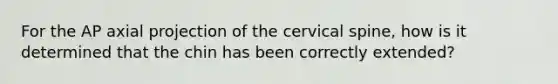 For the AP axial projection of the cervical spine, how is it determined that the chin has been correctly extended?