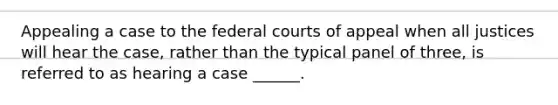 Appealing a case to the federal courts of appeal when all justices will hear the case, rather than the typical panel of three, is referred to as hearing a case ______.