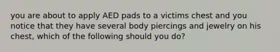 you are about to apply AED pads to a victims chest and you notice that they have several body piercings and jewelry on his chest, which of the following should you do?