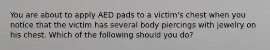 You are about to apply AED pads to a victim's chest when you notice that the victim has several body piercings with jewelry on his chest. Which of the following should you do?