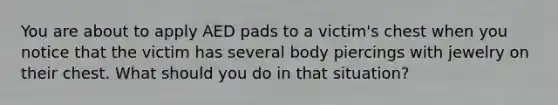 You are about to apply AED pads to a victim's chest when you notice that the victim has several body piercings with jewelry on their chest. What should you do in that situation?