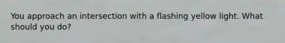 You approach an intersection with a flashing yellow light. What should you do?