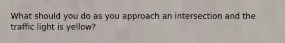 What should you do as you approach an intersection and the traffic light is yellow?