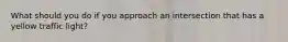 What should you do if you approach an intersection that has a yellow traffic light?