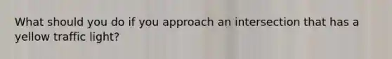 What should you do if you approach an intersection that has a yellow traffic light?