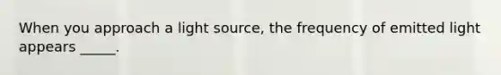 When you approach a light source, the frequency of emitted light appears _____.