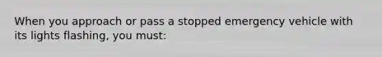 When you approach or pass a stopped emergency vehicle with its lights flashing, you must: