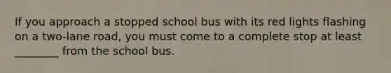 If you approach a stopped school bus with its red lights flashing on a two-lane road, you must come to a complete stop at least ________ from the school bus.