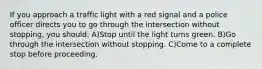 If you approach a traffic light with a red signal and a police officer directs you to go through the intersection without stopping, you should: A)Stop until the light turns green. B)Go through the intersection without stopping. C)Come to a complete stop before proceeding.