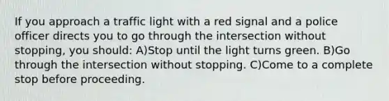 If you approach a traffic light with a red signal and a police officer directs you to go through the intersection without stopping, you should: A)Stop until the light turns green. B)Go through the intersection without stopping. C)Come to a complete stop before proceeding.