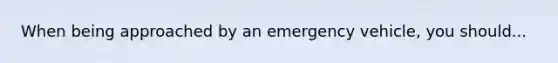 When being approached by an emergency vehicle, you should...