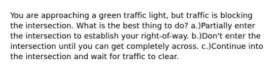 You are approaching a green traffic light, but traffic is blocking the intersection. What is the best thing to do? a.)Partially enter the intersection to establish your right-of-way. b.)Don't enter the intersection until you can get completely across. c.)Continue into the intersection and wait for traffic to clear.