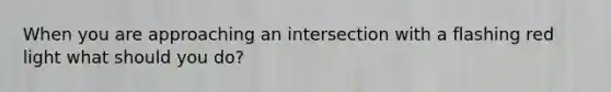 When you are approaching an intersection with a flashing red light what should you do?