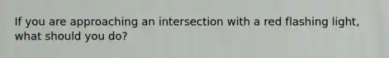 If you are approaching an intersection with a red flashing light, what should you do?