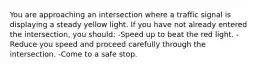 You are approaching an intersection where a traffic signal is displaying a steady yellow light. If you have not already entered the intersection, you should: -Speed up to beat the red light. -Reduce you speed and proceed carefully through the intersection. -Come to a safe stop.