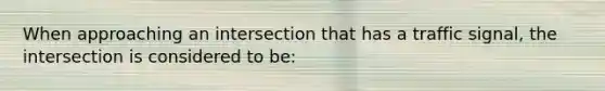 When approaching an intersection that has a traffic signal, the intersection is considered to be: