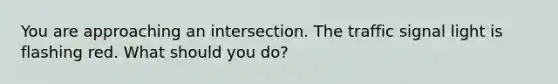 You are approaching an intersection. The traffic signal light is flashing red. What should you do?