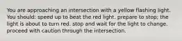 You are approaching an intersection with a yellow flashing light. You should: speed up to beat the red light. prepare to stop; the light is about to turn red. stop and wait for the light to change. proceed with caution through the intersection.