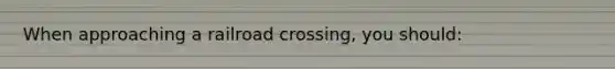 When approaching a railroad crossing, you should: