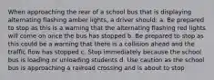 When approaching the rear of a school bus that is displaying alternating flashing amber lights, a driver should: a. Be prepared to stop as this is a warning that the alternating flashing red lights will come on once the bus has stopped b. Be prepared to stop as this could be a warning that there is a collision ahead and the traffic flow has stopped c. Stop immediately because the school bus is loading or unloading students d. Use caution as the school bus is approaching a railroad crossing and is about to stop