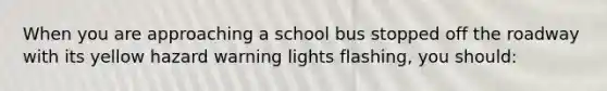 When you are approaching a school bus stopped off the roadway with its yellow hazard warning lights flashing, you should: