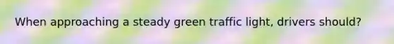 When approaching a steady green traffic light, drivers should?