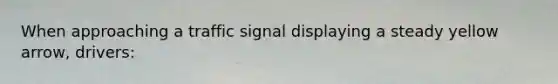 When approaching a traffic signal displaying a steady yellow arrow, drivers: