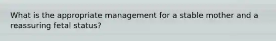 What is the appropriate management for a stable mother and a reassuring fetal status?