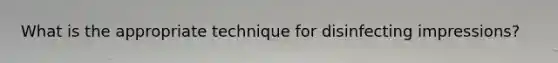 What is the appropriate technique for disinfecting impressions?