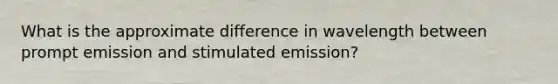 What is the approximate difference in wavelength between prompt emission and stimulated emission?