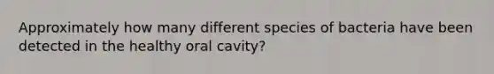 Approximately how many different species of bacteria have been detected in the healthy oral cavity?