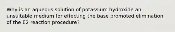 Why is an aqueous solution of potassium hydroxide an unsuitable medium for effecting the base promoted elimination of the E2 reaction procedure?